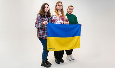 三名乌克兰学生举着他们国家的蓝黄旗.
